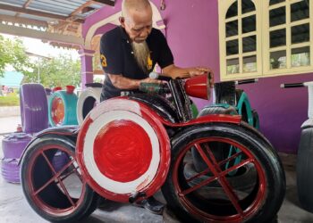 RAHMAT Sulaiman menunjukkan hiasan kreatif berbentuk motosikal dan jam menggunakan tayar terpakai yang dihasilkannya di Felda Kepis, Kuala Pilah. – UTUSAN/NOR AINNA HAMZAH