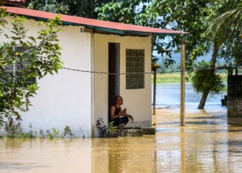 SEORANG penduduk termenung di hadapan rumahnya yang dinaiki air sekali lagi ekoran banjir di Kampung Kubang Betong, Changlun di Kubang Pasu. - UTUSAN/ SHAHIR NOORDIN