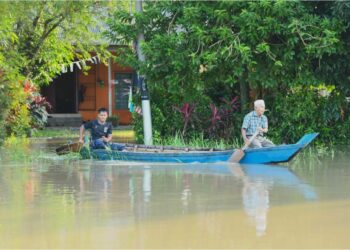 PENDUDUK menggunakan perahu untuk urusan harian selepas terputus hubungan akibat banjir.