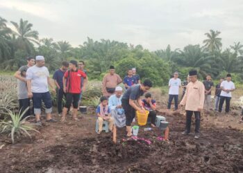 Muhammad Fakhrul Radzi Md. Tukirin menyiram air di pusara  adiknya, Muhammad Akmal pada hari pengkebumiannya dua hari lalu di Tanah Perkuburan Parit Baru, Muar, Johor.