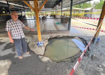 WAN Kharizal Wan Khazim menunjukkan kesan mendapan di kawasan parkir motosikal Masjid As Solihin, Kampung Chuping Bawah Bukit, Padang Besar, Perlis, semalam. – UTUSAN/ASYRAF MUHAMMAD