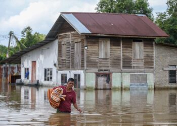 MOHAMAD Rosdi Said meredah banjir di rumahnya yang masih digenangi air di Kampung Banggol Besi, Pendang. Kedah semalam. – UTUSAN/ SHAHIR NOORDIN