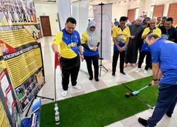 Zahari Ismail memukul 'woodball' sambil disaksikan Tuanku Syed Faizuddin Putra Jamalullail  dalam program Kayuhan Ramah Mesra POLYCC 2024’ di sekitar Kelana Jaya, semalam.