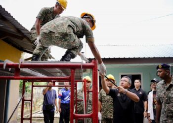 ADLY Zahari membantu anggota tentera membaiki rumah ketika Projek Jiwa Murni (PJM) Peringkat Negeri di Durian Tunggal, Melaka.