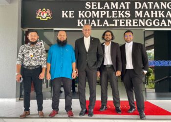 MOHAMAD Azlan Abdullah (dua dari kiri)  bergambar bersama bersama peguam, Datuk Abu Bakar (tengah) dan Sureshmurti Ramani (dua dari kanan) di Kompleks Mahkamah Kuala Terengganu, hari ini. - UTUSAN/TENGKU DANISH BAHRI TENGKU YUSOFF