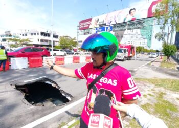 IZZAT IRSYADUDDIN Daud menunjukkan lubang sedalam 1.7 meter yang dielaknya di Jalan Syed Abdul Aziz berhampiran Jalan Melaka Raya, Melaka.