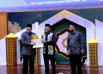 RAHMAD Mariman (tengah) menyampaikan cenderahati kepada salah seorang panel Forum Sempena Sambutan Maulidur Rasul dan Ceramah Kekeluargaan di Auditorium Masjid al-Azim, Bukit Palah, Melaka. - UTUSAN/HADI AB. MANAP