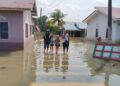 SEBUAH keluarga meredah banjir selepas kediaman mereka di Kampung Kolam Air di Simpang Renggam dinaiki air.