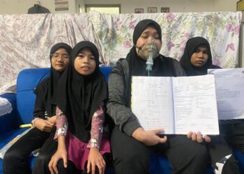 NORFARAHAIN Abd. Manap yang memakai tiub oksigen untuk bernafas menunjukkan buku rawatannya semasa ditemui di Taman Pelangi, Johor Bahru.