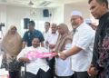 AIMAN Athirah Sabu (dua dari kanan) menyampaikan replika kunci rumah kepada  penghuni PRR Bukti Nenas di Kuala Nerus,  hari ini. - UTUSAN/KAMALIZA KAMARUDDIN