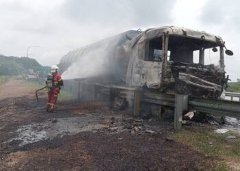 ANGGOTA bomba memadamkan kebakaran membabitkan sebuah lori tangki membawa muatan minyak sawit yang terbabas lalu masuk ke laluan bertentangan dalam kejadian di Kilometer 44.6 Lebuhraya Utara Selatan Hubungan Tengah (Elite) arah ke utara dekat Nilai, Seremban tengah hari tadi.-GAMBAR/IHSAN BOMBA.