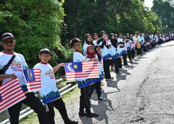 SEBAHAGIAN daripada peserta yang melakukan  formasi 'The Longest Jalur Gemilang Human Trail@Bukit Bauk' di Bukit Bauk, Dungun, hari ini. - UTUSAN/PUQTRA HAIRRY ROSLI