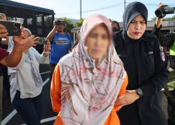 ANGGOTA polis mengiringi wanita yang dipercayai merempuh dua buah motosikal sehingga menyebabkan kematian tiga pelajar UiTM di Mahkamah Majistret Dungun, hari ini. - UTUSAN/PUQTRA HAIRRY ROSLI