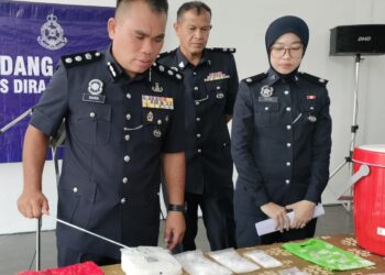 BAHRIN Mohd. Noh (kiri) menunjukkan dadah yang ditemui dalam sebuah rumah disewa lima individu di Kampung Chokro, Simpang Renggam.