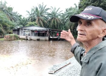 MOHAMAD Ibrahim menunjukkan keadaan rumahnya di Kampung Talang Bunut, Batu Pahat yang masih dilanda banjir.