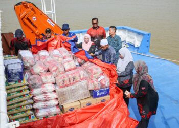 MAZURA Ngah Abd Manan (dua, kanan) meninjau persiapan penghantaran bekalan  keperluan banjir ke pengkalan hadapan Pulau Redang di Jeti Jabatan Laut Malaysia, Kuala Terengganu, hari ini. - UTUSAN/PUQTRA HAIRRY ROSLI