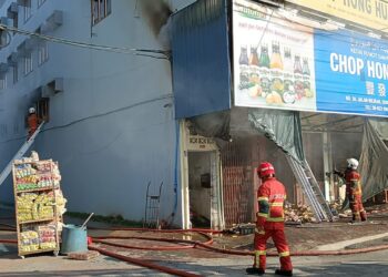 ANGGOTA bomba memeriksa premis perniagaan yang terbakar di Jalan Hiliran, Kuala Terengganu, hari ini. - UTUSAN/TENGKU DANISH BAHRI TENGKU YUSOFF