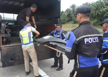 ANGGOTA polis mengusung mayat Nur Hamizul Abu Bakri yang maut selepas motosikal EX5 ditunggangi terlibat dalam kemalangan di Kilometer 316.8,  LPT2, berhampiran Kerteh, Kemaman, hari ini. - UTUSAN/NIK NUR IZZATUL HAZWANI NIK ADNAN