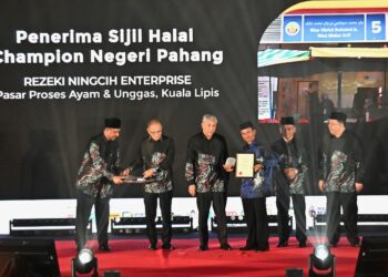 AHMAD ZAHID Hamidi menyampaikan sijil halal kepada seorang penerima pada Program Halal On Track (HOT) Pahang Darul Makmur di Dewan Jubli Perak Sultan Ahmad Shah di Kuantan, Pahang. - FOTO/SHAIKH AHMAD RAZIF