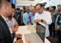 ANWAR Ibrahim bersama Hajiji Noor semasa melawat gerai pameran pada SIBEC di SICC Kota Kinabalu hari ini.