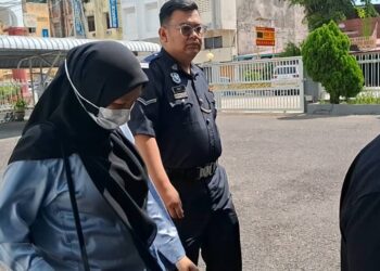 ZULAIKHA Mohd. Arifin diiring polis dibawa masuk ke Mahkamah Sesyen Kemaman, hari ini. - UTUSAN/NIK NUR IZZATUL HAZWANI NIK ADNAN/