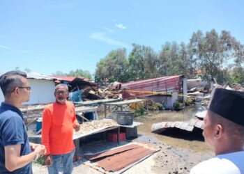 MOHD. FARED Mohd  Khalid (kiri) meninjau rumah lima keluarga yang musnah dalam kebakaran di Kampung Sungai Ayam, Batu Pahat.