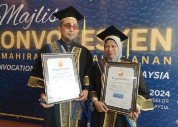 HASIDI Hassan dan Siti Hadijah menerima anugerah lhas pada Majlis Konvokesyen Kemahiran dan Keusahawanan TVETec Malaysia yang diadakan di USIM, Nilai, Seremban hari ini.-UTUSAN/NUR SHARIEZA ISMAIL.