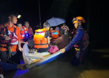 ANGGOTA Angkatan Pertahanan Awam (APM) memindahkan penduduk yang terperangkap banjir di Baling. - IHSAN APM