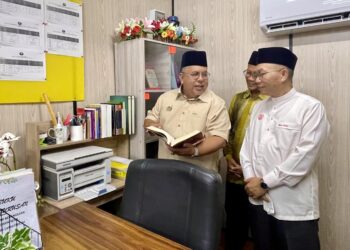 ABD. Ghani Zainuddin (kiri) meninjau projek kabin guru KAFA selepas majlis penyerahan di SK Pokok Sena.