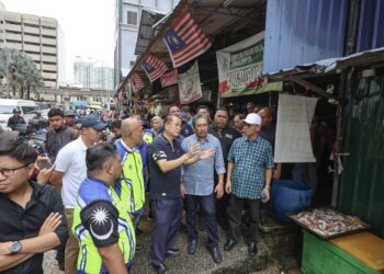 JOHARI Abdul Ghani diberi penerangan ketika melawat  Kompleks Pasar Raja Bot di Kuala Lumpur semalam.