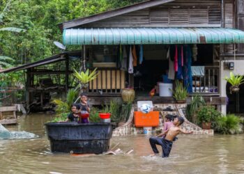 Beberapa kanak-kanak bermain air banjir  di Kampung Lengkuas Mukim Derang semalam.