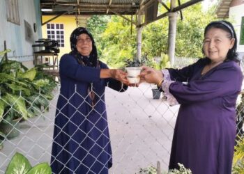 MEK Sewin Chaw (kanan) beramah mesra dengan jirannya dari kaum Melayu di Kampung Chenderong, Teluk Jering, Tumpat, Kelantan.
– UTUSAN/ROHANA ISMAIL