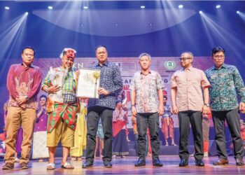 MOHD. Yusri Mohd. Yusof menyampaikan cenderahati penghargaan kepada Pengarah Teater `Putera Cahaya Bulan’ , Mohd. Yusuf Azizan pada Pementasan Karya Agung Teater Tradisional Mek Mulung dekat Dewan Seri Budiman, di UiTM Shah Alam, Selangor. – UTUSAN/MUHAMAD IQBAL ROSLI