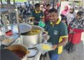 MOHAMAD Fadzil Abdul Wahab (kiri) dan sepupunya Che Hajirah Bee Abdul Hamid (kanan) mengedarkan nasi kandar percuma di sekitar Pulau Pinang.