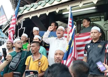 PESURUHJAYA Pas Perak, Razman Zakaria (tengah) berucap pada Himpunan Kibarkan Jalur Gemilang di hadapan Menara Condong di Teluk Intan semalam. - UTUSAN