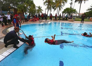 NICOLE Tan Lee Koon bersama Haziz ketika melihat peserta yang menjalani latihan pada Program Latihan Water Confidence dan Teknik Penyelamatan di Air Bagi Kakitangan Jabatan Keselamatan dan Rekreasi Hotel/Resort Negeri Sembilan di Port Dickson hari ini. - UTUSAN/MOHD. SHAHJEHAN MAAMIN