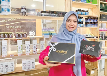 AISHAH Azizan menunjukkan antara produk coklat jenama Nokona yang dihasilkan di kilang CnW Jitra Manufacturing di Taman Industri KEDA, Napoh Kubang Pasu.