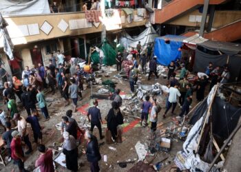 PENDUDUK Palestin berkumpul selepas serangan Israel melanda sekolah Rufaida yang menempatkan orang awam kehilangan tempat tinggal di Deir al-Balah, tengah Gaza semalam.- AFP