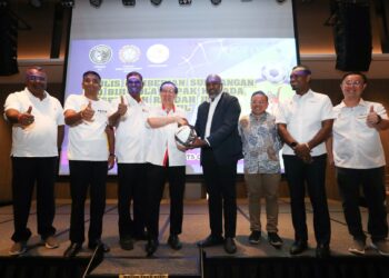 Ketua Pegawai Eksekutif ShekhinahPR, Christopher Raj (empat dari kanan) menyampaikan bola kepada Lim Guan Eng sebagai simbolik penyerahan sumbangan kepada 28 sekolah di Pulau Pinang.