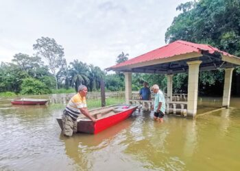 NELAYAN memeriksa bot mereka berhampiran jeti yang tenggelam akibat air Sungai Kinta melimpahi tebing di Kampung Batang  Pelanduk dekat Pasir Salak, semalam. – UTUSAN/AIN SAFRE BIDIN