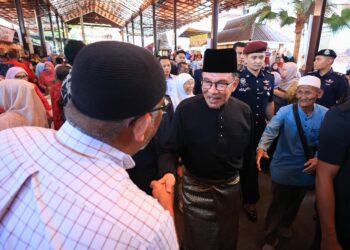 ANWAR Ibrahim (kanan) bersalam dengan orang ramai semasa mengadakan lawatan ke Pasar Siti Khadijah, Kota Bharu, Kelantan semalam-UTUSAN/KAMARUL BISMI KAMARUZAMAN.