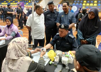 RUSDI MOHD ISA melakukan saringan kesihatan ketika majlis perasmian Taman Angkat Amanita, di Kompleks Kejiranan Presint 11, Putrajaya. - UTUSAN/MOHD HUSNI MOHD NOOR