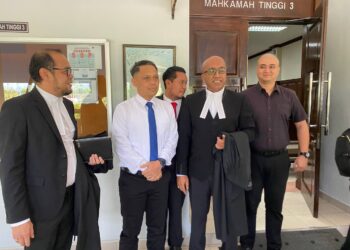 ROSLAN SAM (dua dari kiri) bersama peguamnnya Haresh Mahadevan dan Ramzani Idris di luar Mahkamah Tinggi, Seremban hari ini.-UTUSAN/NOR SHAFAWATI YUP.