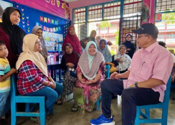 SHAHIDAN Kasim (kanan) berbual bersama salah seorang mangsa ketika meninjau mangsa banjir di PPS SK Sena, Kangar, Perlis semalam. -UTUSAN/ASYRAF MUHAMMAD