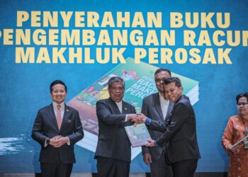 MOHAMAD Sabu (dua,kiri) menyerahkan Buku Pengembangan Racun Makhluk Perosak kepada wakil Jabatan di Putrajaya. - UTUSAN/FAIZ ALIF ZUBIR