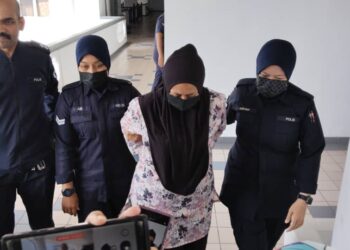 TERTUDUH diiringi anggota polis ketika dihadapkan ke Mahkamah Sesyen, Ayer Keroh, Melaka. - UTUSAN/MUHAMMAD SHAHIZAM TAZALI