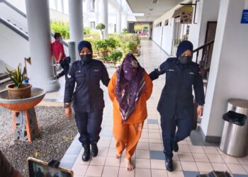 TERTUDUH diiringi anggota polis ketika dihadapkan ke Mahkamah Sesyen, Ayer Keroh, Melaka. - UTUSAN/MUHAMMAD SHAHIZAM TAZALI