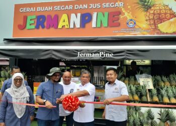 MOHAMMAD Sabu  memotong pita perasmian Gerai Buah Segar Jermanpine  di  Kampung Parit Jerman, di Pontian, Johor, hari ini.