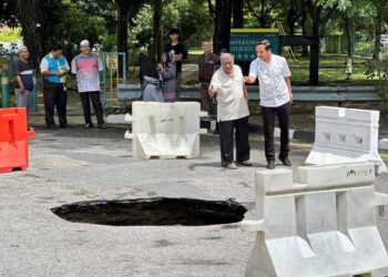 FAHMI Zainol (kanan) ketika meninjau lokasi kejadian lubang benam di Taman Sri Nibong, Pantai Jerejak, Pulau Pinang, hari ini.