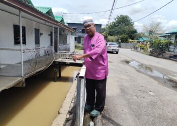 ZUHAIRI Abidin menunjukkan lokasi tiga ekor ikan arapaima yang dibela di Kampung Seri Tanjung, Masjid Tanah, Melaka sebelum dipindahkan ke Zoo Negara. - UTUSAN/AMRAN MULUP